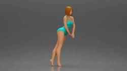 woman in a turquoise swimsuit striking a pose