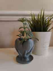 Drenajlı kalp saksıyı tutan eller